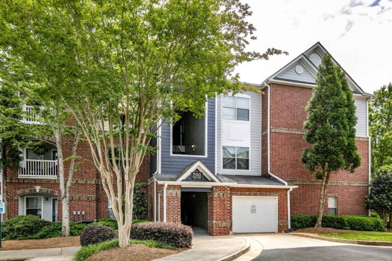 Three story apartment building with garage private single car garage .